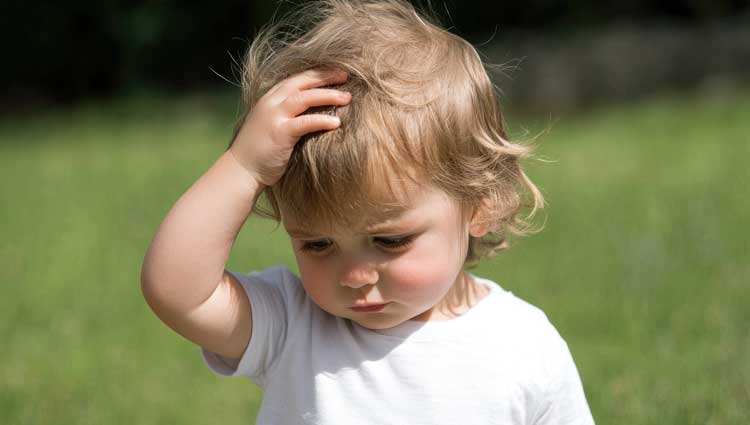 Picture of a child with hand over head acting confused