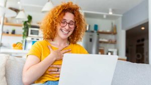 Young woman reading email laughing