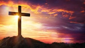 Cross on top of a mountain during sunset in background, for a planned giving article on church fundraising.