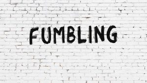 An image of the words "fumbling" written on a white brick wall, to illustrate a plannedgiving.com post on a football family's fumbled estate planning.