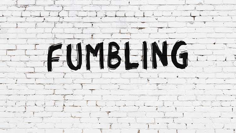 The words "Fumbling" written on a brick wall.