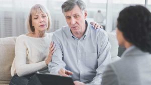 An image of an older couple meeting with a lawyer to discuss their living will