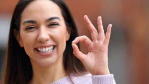 Woman with hand sign "A OK" saying yes.